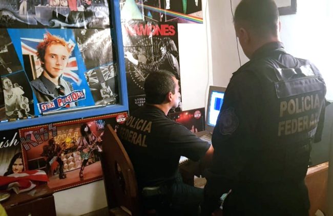 Policiais federais analisam o computador de um dos presos
